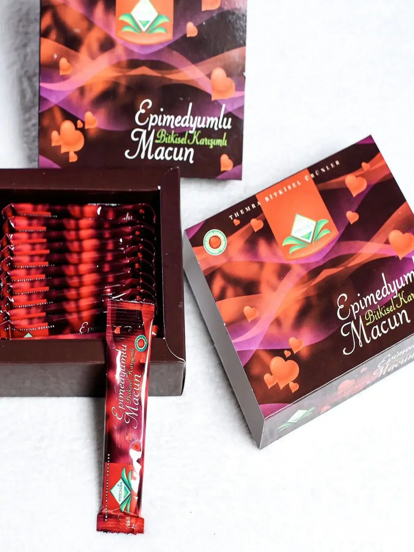 Themra Epimedium Macun packaging with individual sachets featuring vibrant red design and herbal blend for vitality.